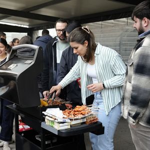 People are standing around a grill