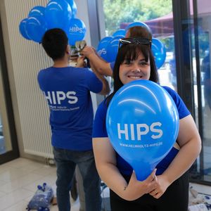 A person holds a blue HIPS balloon up to the camera
