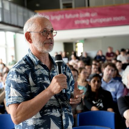Man with microphone in front of public