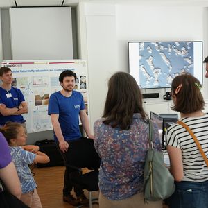 Two people in blue shirts are giving a presentation